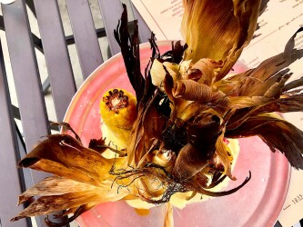A WITCH'S BROOM?: Roasted corn stands over lemon aioli beneath a headdress designed by the Wicked Witch of the West. Photo credit: Cliff Bostock